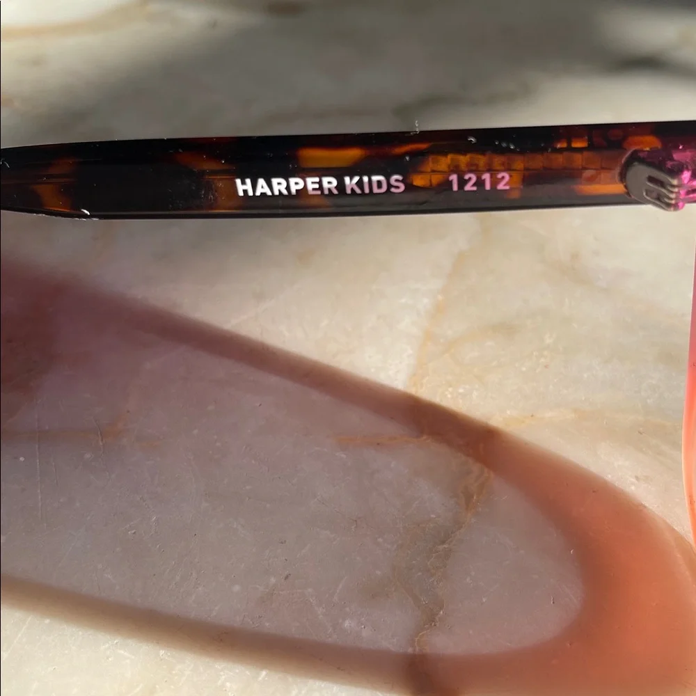 Quay Harper Kids cat-eye sunglasses with coral pink and smoke lenses.